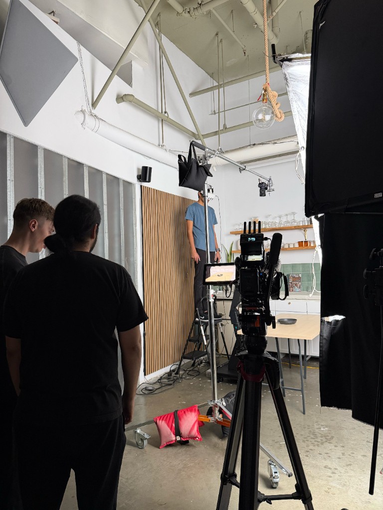 Crew watching the monitor while a founder sets up the kitchen demo set